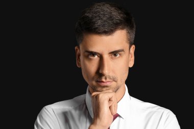 Koyu arka plan üzerinde yakışıklı işadamı portresi