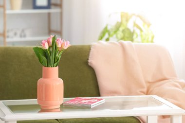 Oturma odasının içinde lale çiçekleri olan şık bir vazo.