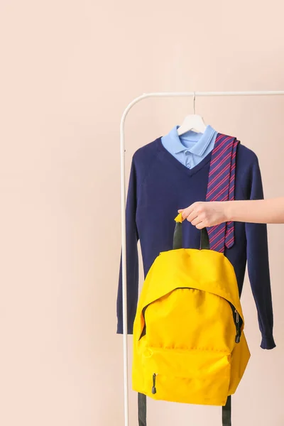 Stijlvol Schooluniform Hangend Aan Rek Vrouwelijke Hand Met Rugzak Tegen — Stockfoto