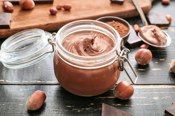 Jar Dengan Pasta Coklat Lezat Dan Hazelnut Atas Meja — Stok Foto