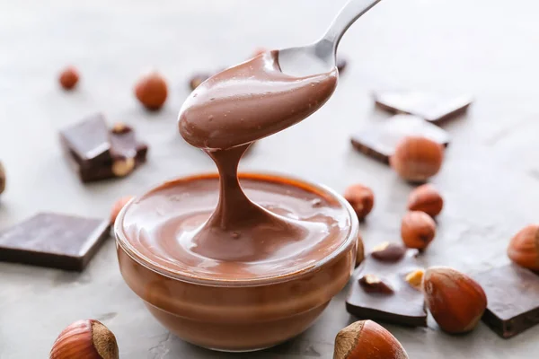 Lezzetli Çikolata Ezmeli Kase Kaşık Arkaplanda Fındık — Stok fotoğraf