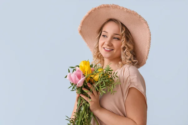 色の背景上の花の花束と美しい若い女性 — ストック写真