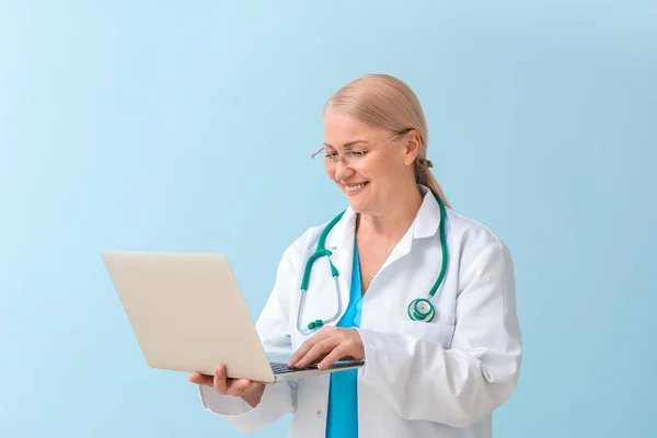 Médico Feminino Maduro Com Laptop Fundo Cor — Fotografia de Stock