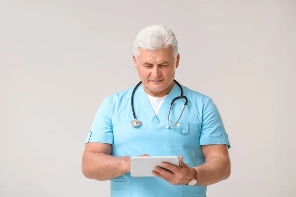 Mature Male Doctor Tablet Computer Grey Background — Stock Photo, Image