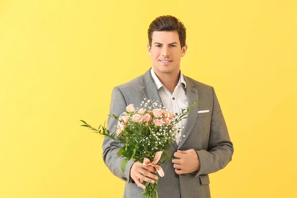 色の背景に花の花束を持つハンサムな男 — ストック写真