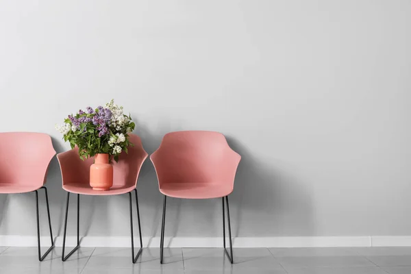 Stylish Armchairs Beautiful Lilac Flowers Grey Wall — Stock Photo, Image
