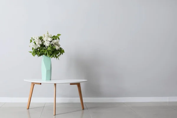 Gri Duvarın Yanındaki Masada Güzel Leylak Çiçekleri — Stok fotoğraf