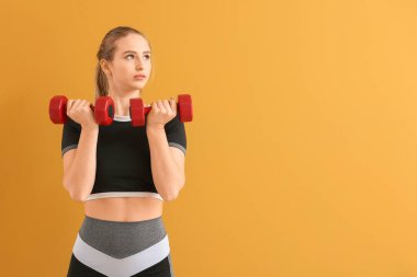 Renkli arka planda dambıllarla spor yapan genç bir bayan.