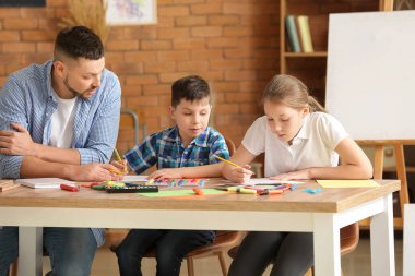 Okulda isteğe bağlı ders veren çizim öğretmeni.