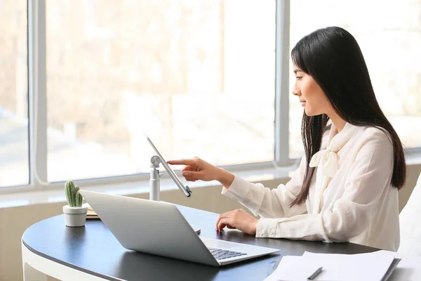 Beautiful Asian secretary working in office