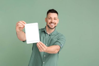 Arkaplanda tablet bilgisayarı olan yakışıklı bir adam