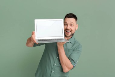 Renkli dizüstü bilgisayarı olan yakışıklı adam.