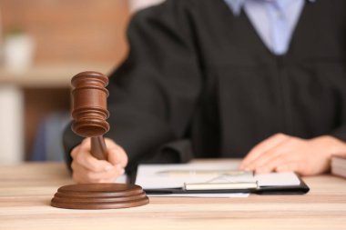 Masasında tokmak olan kadın yargıç, yakın plan.