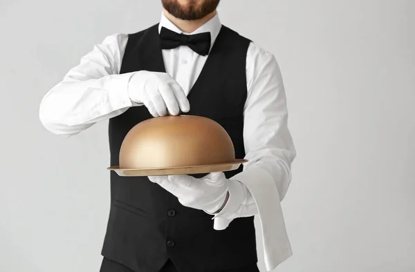 Kellner Mit Tablett Und Cloche Auf Grauem Hintergrund — Stockfoto