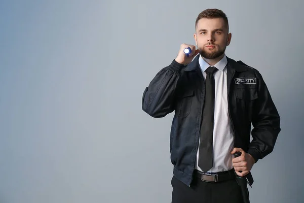 Männlicher Wachmann Mit Taschenlampe Auf Grauem Hintergrund — Stockfoto