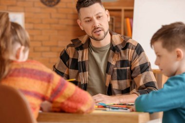 Okulda isteğe bağlı ders veren çizim öğretmeni.