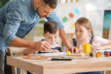 Okulda isteğe bağlı ders veren çizim öğretmeni.