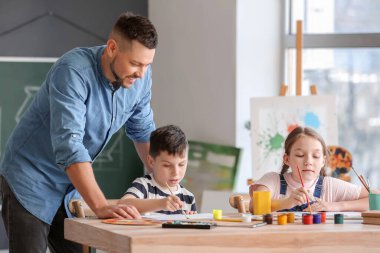 Okulda isteğe bağlı ders veren çizim öğretmeni.