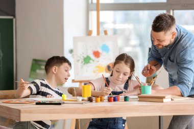 Okulda isteğe bağlı ders veren çizim öğretmeni.