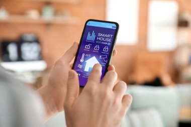 Akıllı ev otomasyonu uygulaması kullanan adam