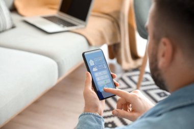 Akıllı ev otomasyonu uygulaması kullanan adam