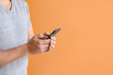 Renkli arka planda cep telefonu olan adam