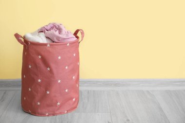 Duvarın yanında kirli sepet var.