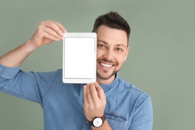 Arkaplanda tablet bilgisayarı olan yakışıklı bir adam