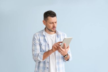 Arkaplanda tablet bilgisayarı olan yakışıklı bir adam