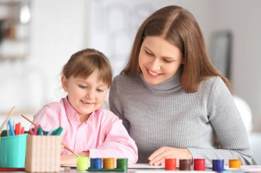 Çizim öğretmeni evde küçük bir kıza özel sanat dersleri veriyor.