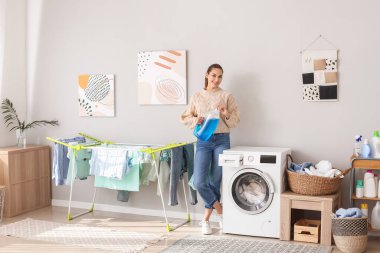 Evde çamaşır yıkayan genç bir kadın.