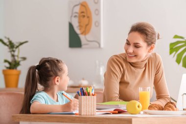 Evde küçük kızıyla birlikte çalışan bir anne.