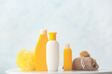 Banyoda farklı duş jelleri, havlu ve banyo lifleri var.