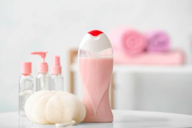 Banyodaki masada farklı duş jelleri ve banyo lifleri var.