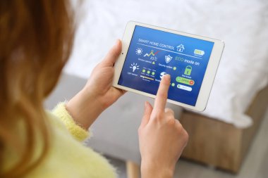 Akıllı ev otomasyonu uygulaması kullanan kadın