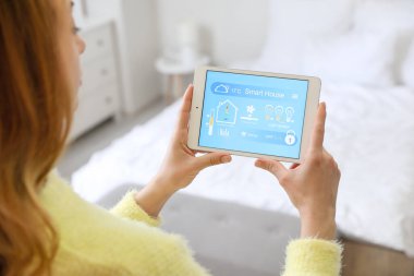 Akıllı ev otomasyonu uygulaması kullanan kadın