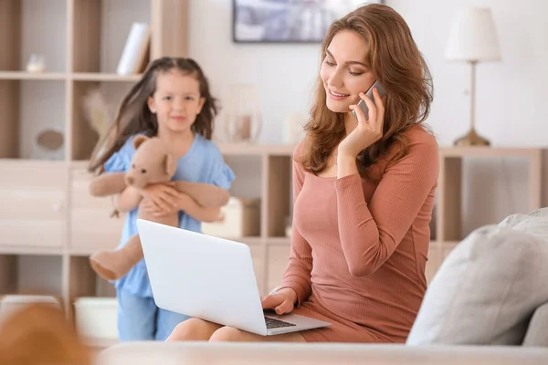 Working mother with little daughter at home