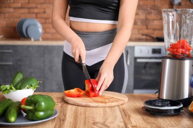 Sportif kadın evde mutfakta smoothie yapıyor, yakın plan.