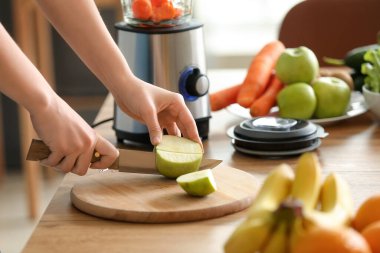 Genç bir kadın mutfakta smoothie yapıyor, yakın plan.