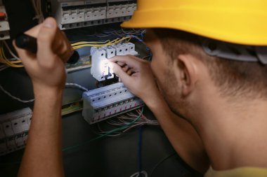 El feneri dağıtım panosunu tamir eden erkek elektrikçi.