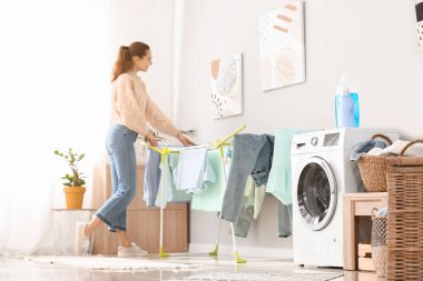 Evde çamaşır yıkayan genç bir kadın.