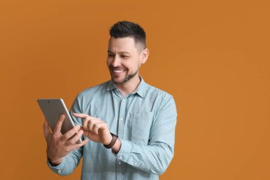 Arkaplanda tablet bilgisayarı olan yakışıklı bir adam