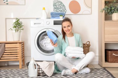 Güzel genç bayan evde çamaşır yıkıyor.