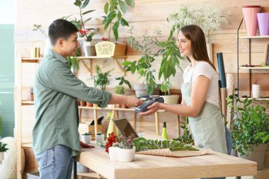Çiçekçi dükkanında sipariş için ödeme yapan müşteri