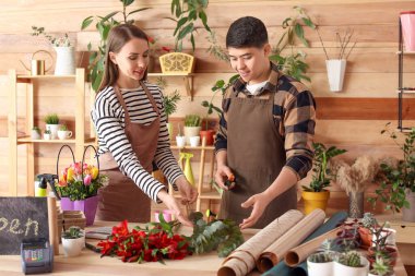Çiçekçiler dükkanda birlikte çalışıyorlar.