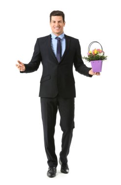 Beyaz arka planda çiçek demeti olan yakışıklı bir adam.