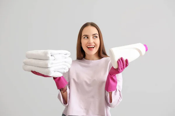 Bella Giovane Donna Con Asciugamani Puliti Detergente Sfondo Grigio — Foto Stock