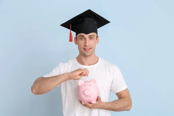 卒業帽子の若い男と光の背景に貯金箱で 授業料概念 — ストック写真