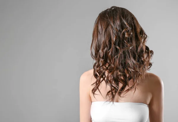 Junge Frau Mit Schönen Kurzen Welligen Haaren Auf Grauem Hintergrund — Stockfoto