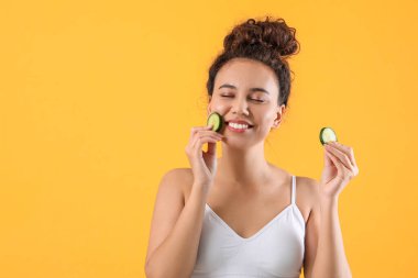 Renkli salatalık dilimleri olan güzel bir Afro-Amerikalı kadın.